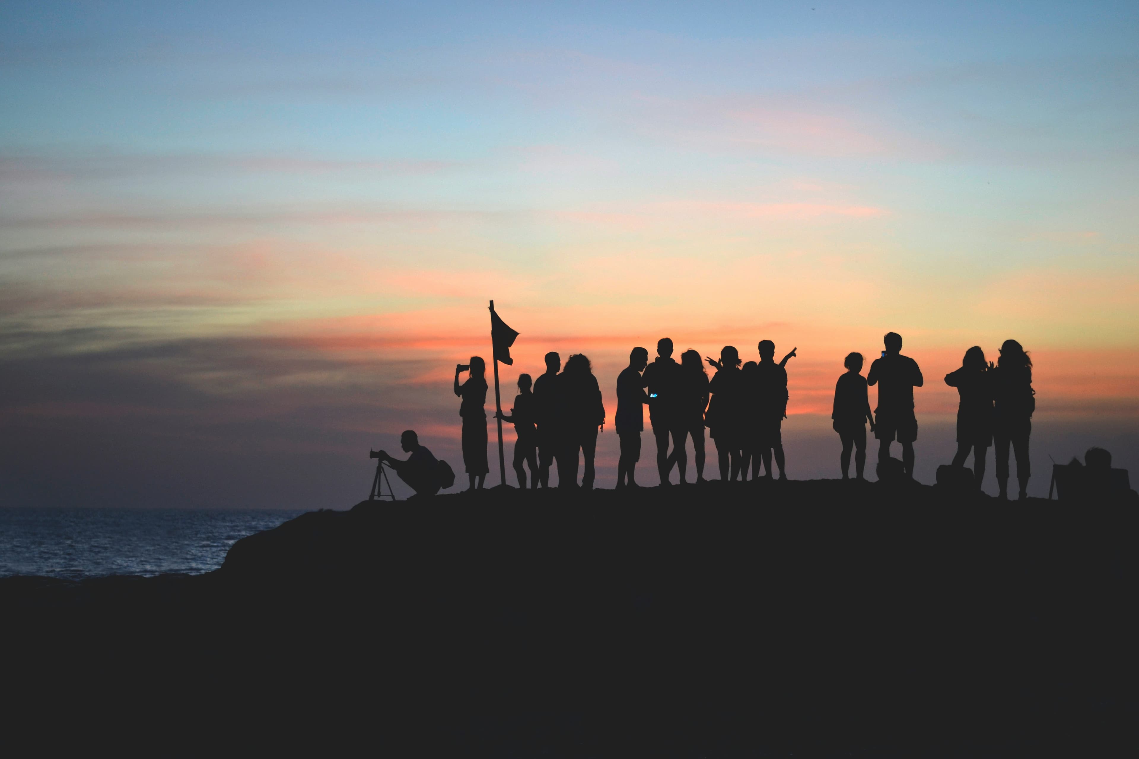 Un groupe réuni au bord de l’eau au coucher du soleil